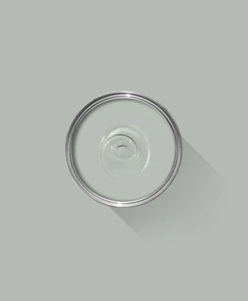 A metal can viewed from above on a light gray background, showing the circular lid and a spiral pattern in the center, with a long shadow cast to the right.