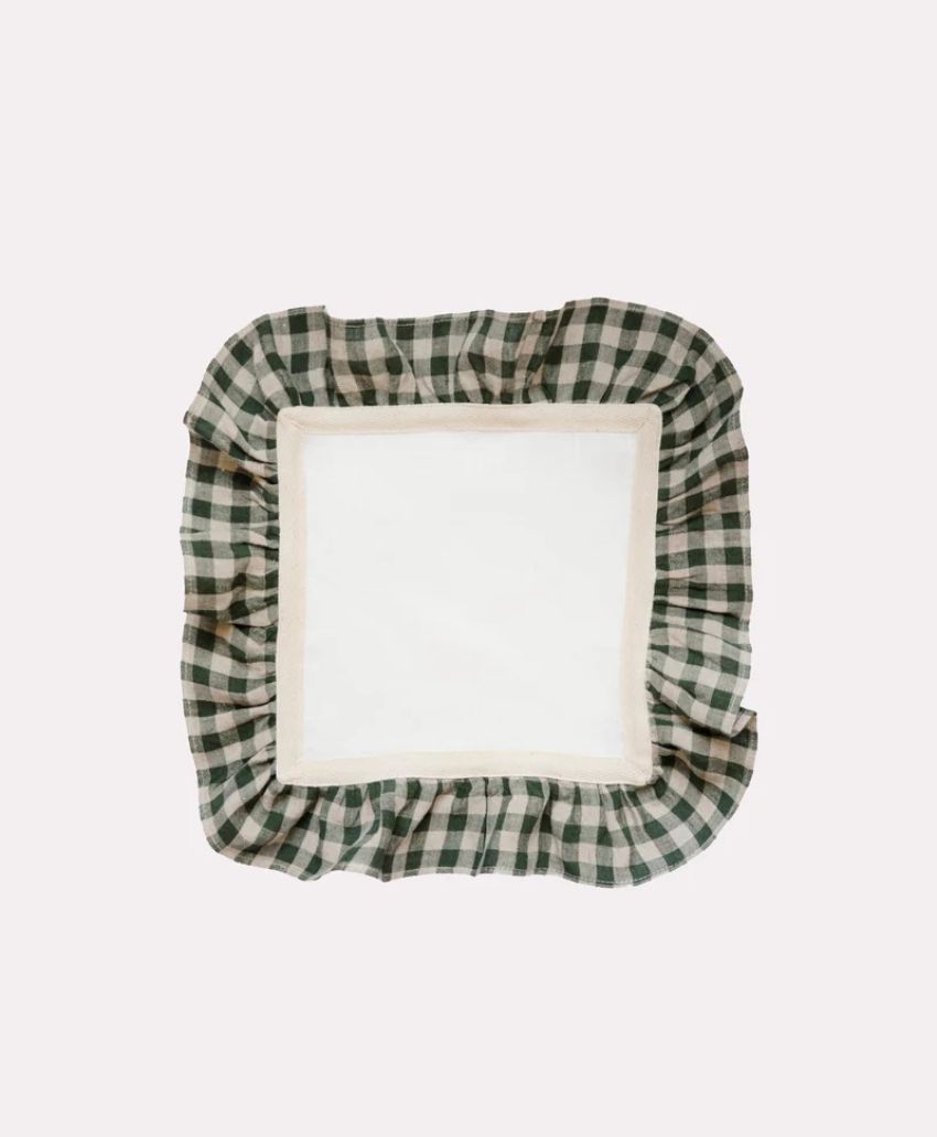 A square cloth napkin with a white center and a green and white gingham ruffled border, set against a plain light background.