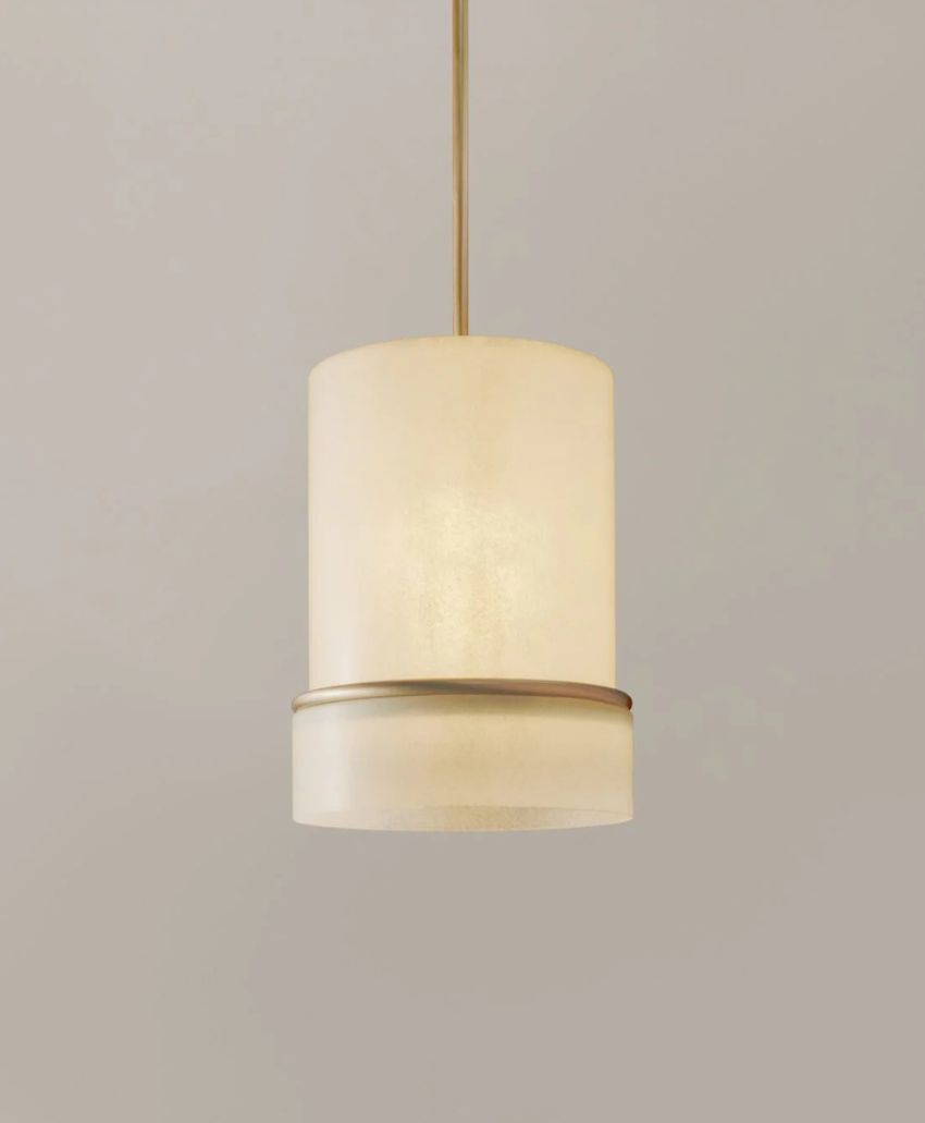 A modern pendant light with a cylindrical, frosted glass shade and a thin, metallic band around its lower section, suspended from a matching metallic rod against a plain, light-colored background.