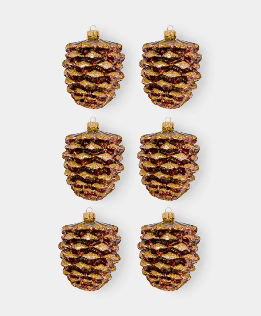 Six glittery pine cone-shaped ornaments arranged in two columns and three rows on a plain light background.