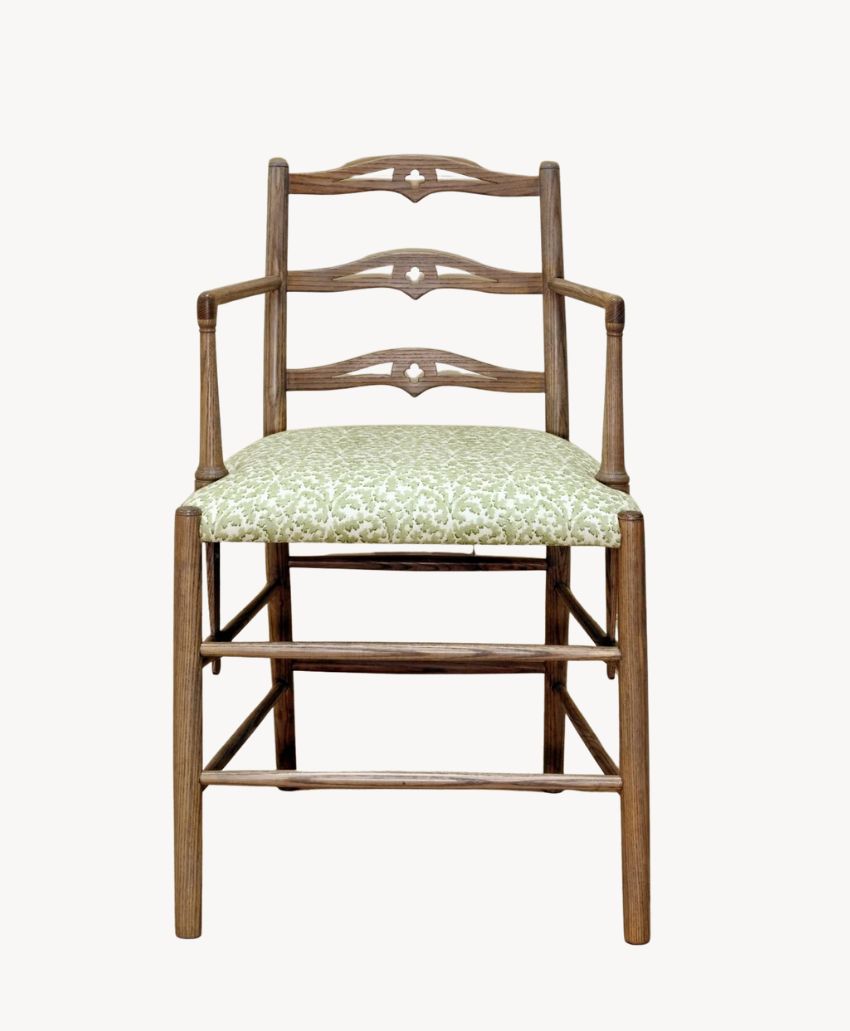 Wooden chair with decorative backrest bars, armrests, and a cushioned seat upholstered in a light green floral-patterned fabric, shown against a plain white background.