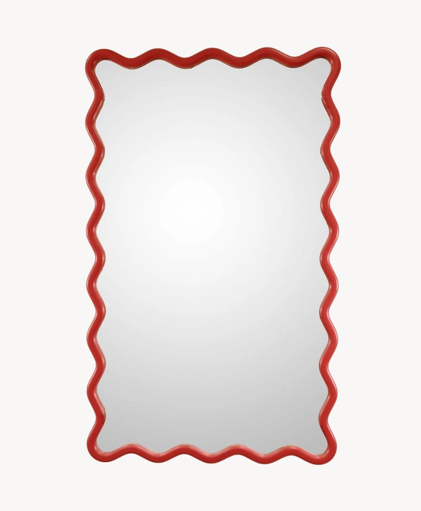 A rectangular mirror with a wavy, bright red frame, set against a plain white background.