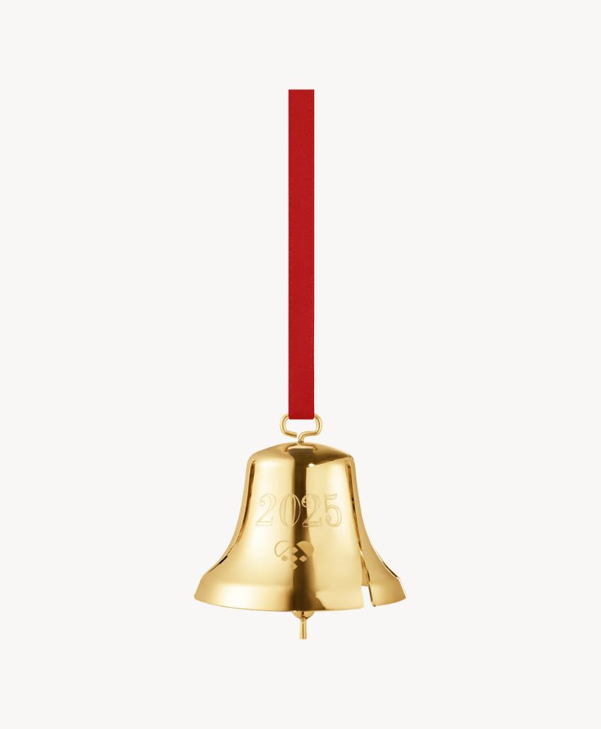 A shiny gold bell ornament with 2023 engraved on it, hanging from a red ribbon against a plain white background.