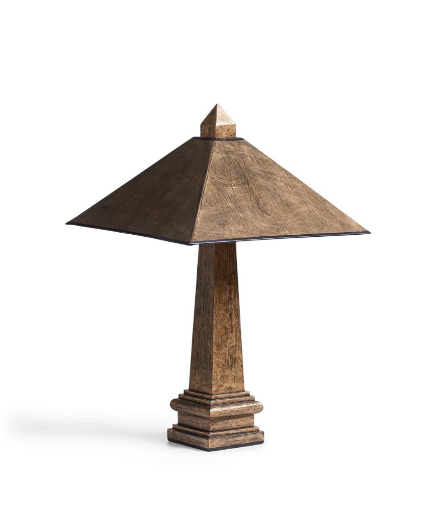 A table lamp with a pyramid-shaped base and a matching triangular lampshade, both in a rustic brown finish. The lamp has a geometric, architectural design.