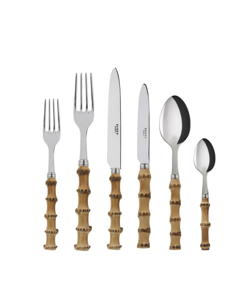 A set of six utensils with metallic tops and bamboo-style handles, including two forks, two knives, a spoon, and a teaspoon, arranged upright in a row against a white background.