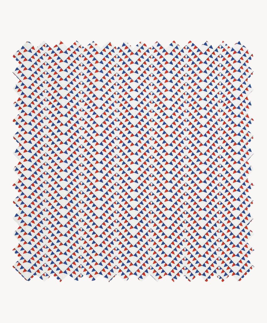 A patterned fabric square featuring a diagonal grid of small red, blue, and white triangles, creating a repeating geometric design on a white background.