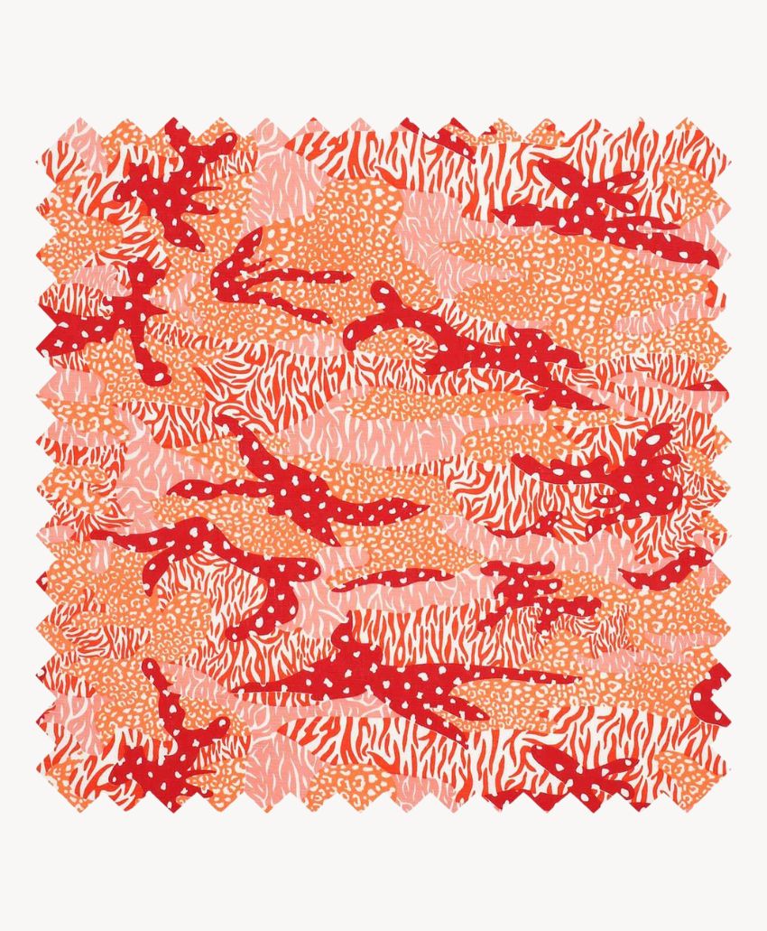 A square fabric swatch with jagged edges featuring an abstract pattern in red, pink, and orange, including polka dots and wavy striped shapes.