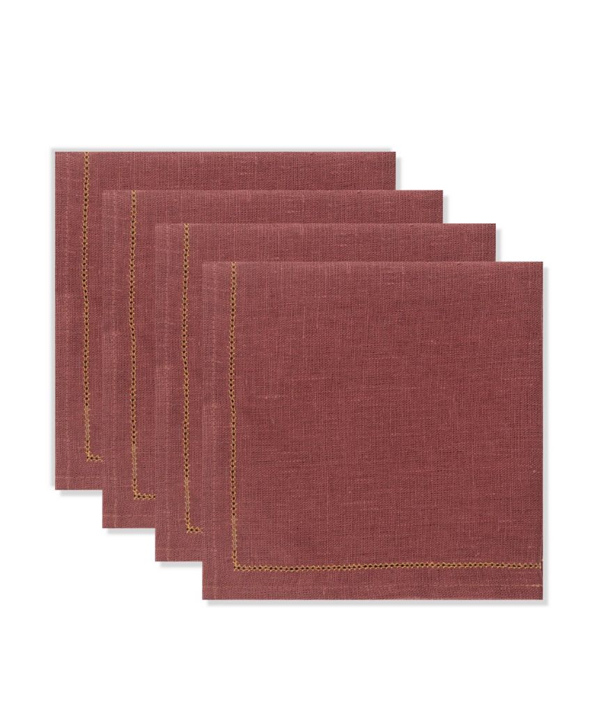 Four maroon cloth napkins are stacked in a staggered arrangement, each featuring a simple stitched border near the edge.
