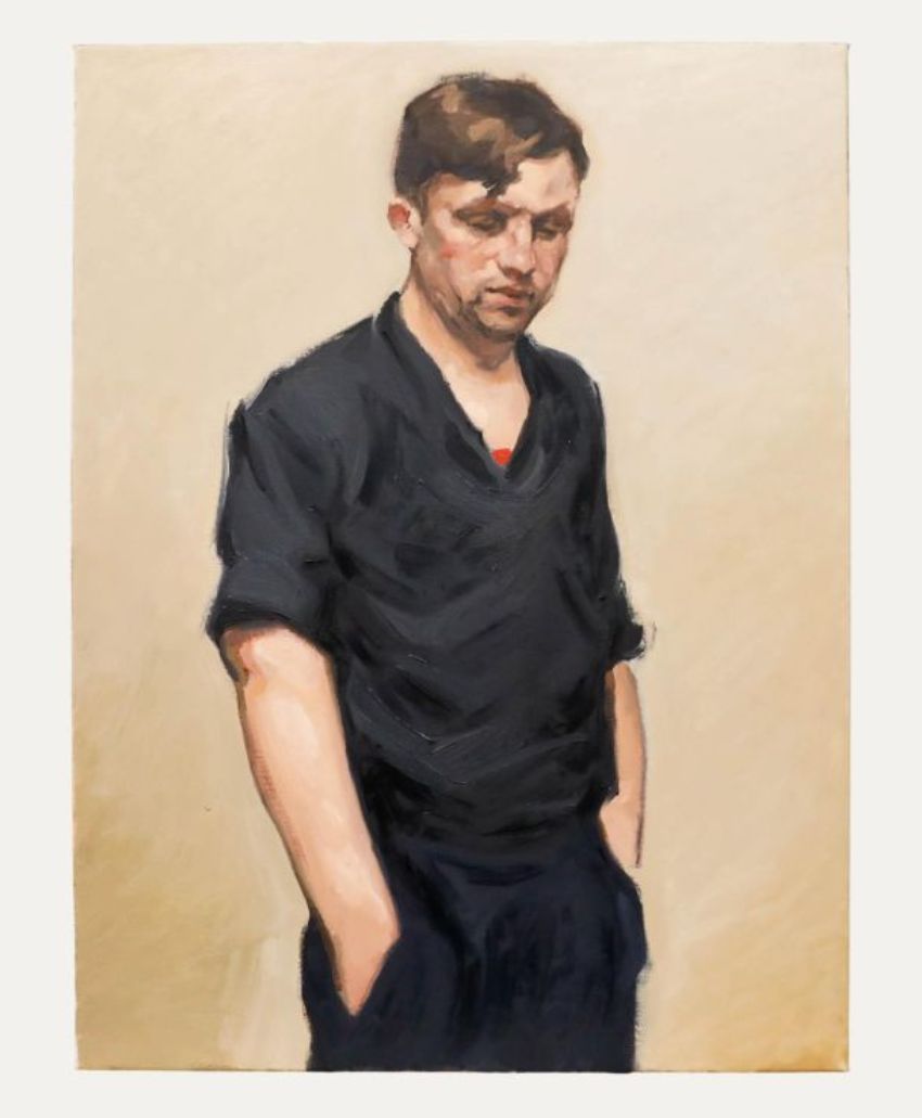 A painted portrait of a man with short brown hair, wearing a loose black shirt and trousers, standing with his hands in his pockets, looking down with a neutral expression against a plain beige background.
