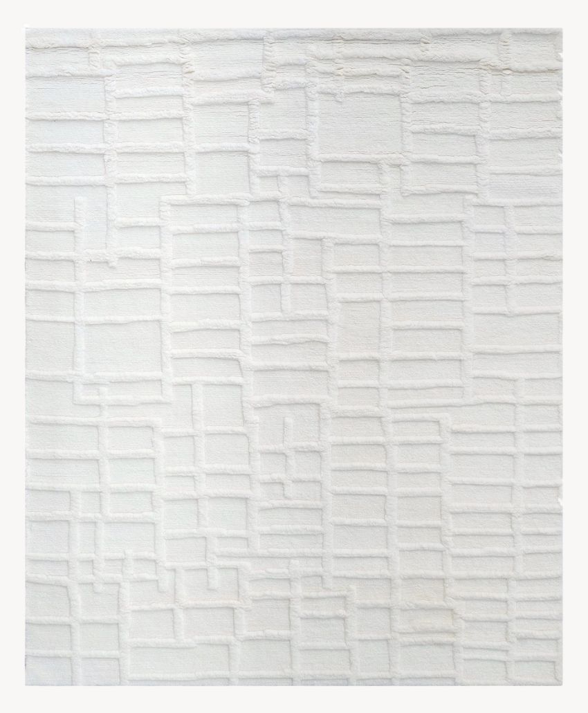 White rug with a raised, geometric grid pattern of rectangles and squares, creating a subtle textured design. The background and pattern are both shades of white.