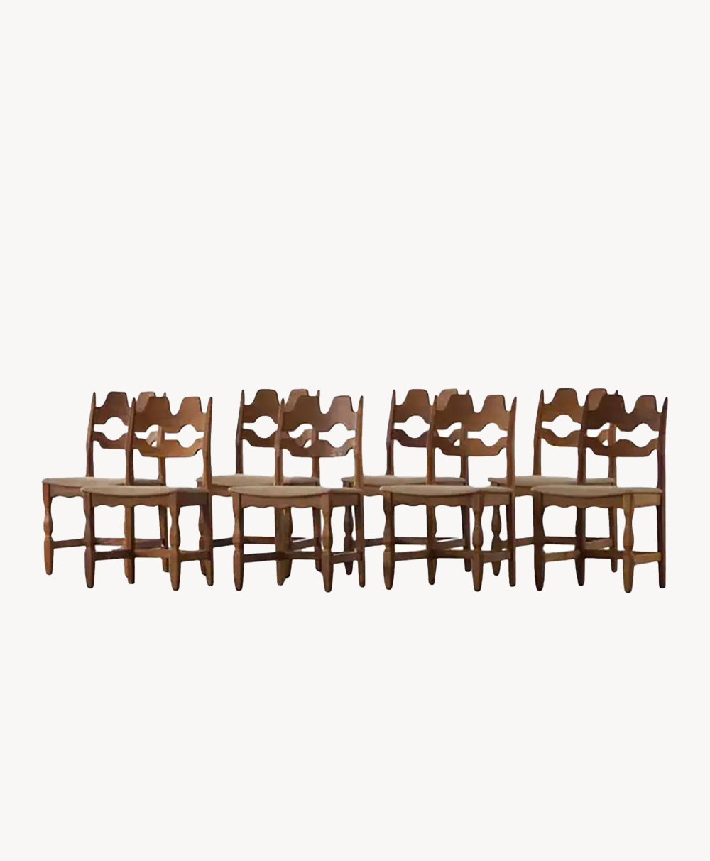 Five vintage wooden chairs with curved, decorative backrests and simple seats are arranged side by side against a plain white background.
