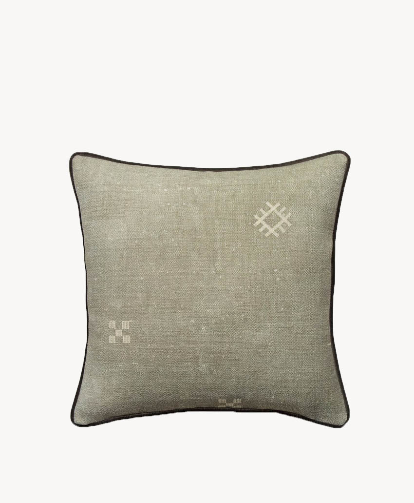 A square light gray cushion with subtle stitched geometric patterns and dark piping along the edges, placed against a plain white background.