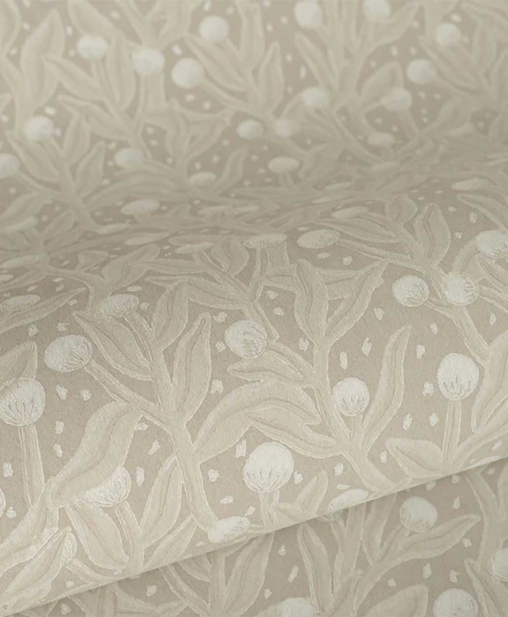 A close-up of beige fabric with a subtle, raised botanical pattern featuring leaves and round buds, creating a textured, elegant design.