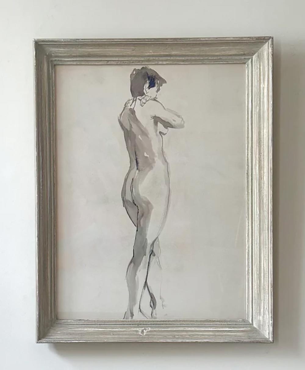 A framed artwork depicts a nude figure standing with their back to the viewer, head turned slightly to the left, sketchily rendered with soft shading and delicate lines against a plain background.
