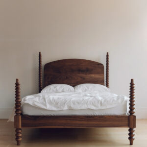 A bed with white sheets and pillows.
