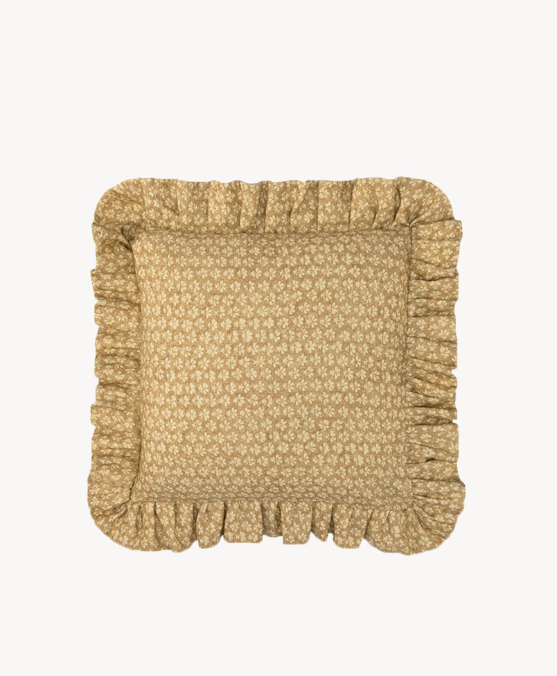 Square cushion with a light brown fabric featuring a small white floral pattern and ruffled edges, shown against a plain white background.