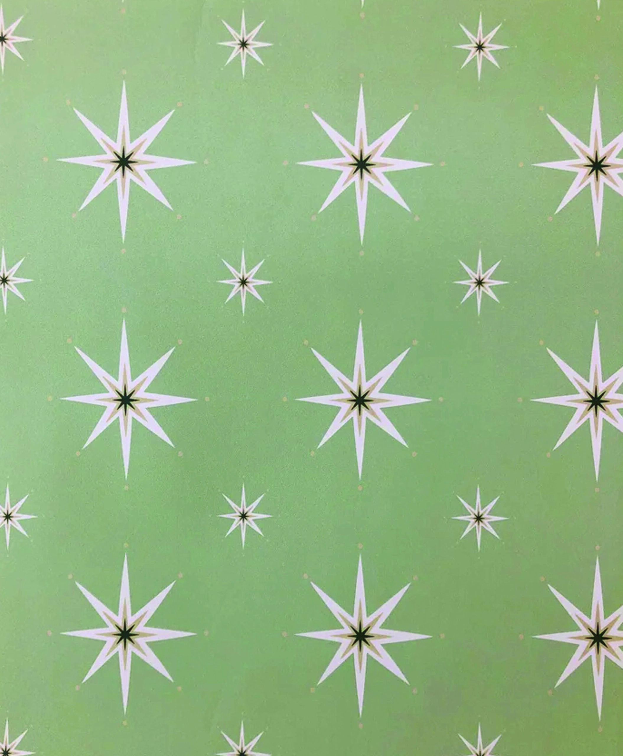 A green background with a repeating pattern of white compass stars, each with eight points and a dark green center. The design is evenly spaced and symmetrical.