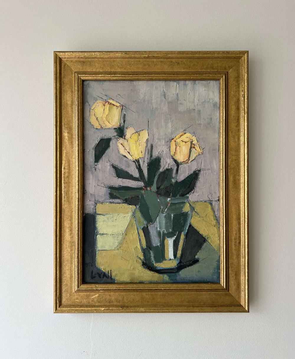 Framed painting of three yellow flowers in a glass vase with green leaves, set against a muted gray and yellow background. The frame is gold, and the artwork has a textured, impressionistic style.