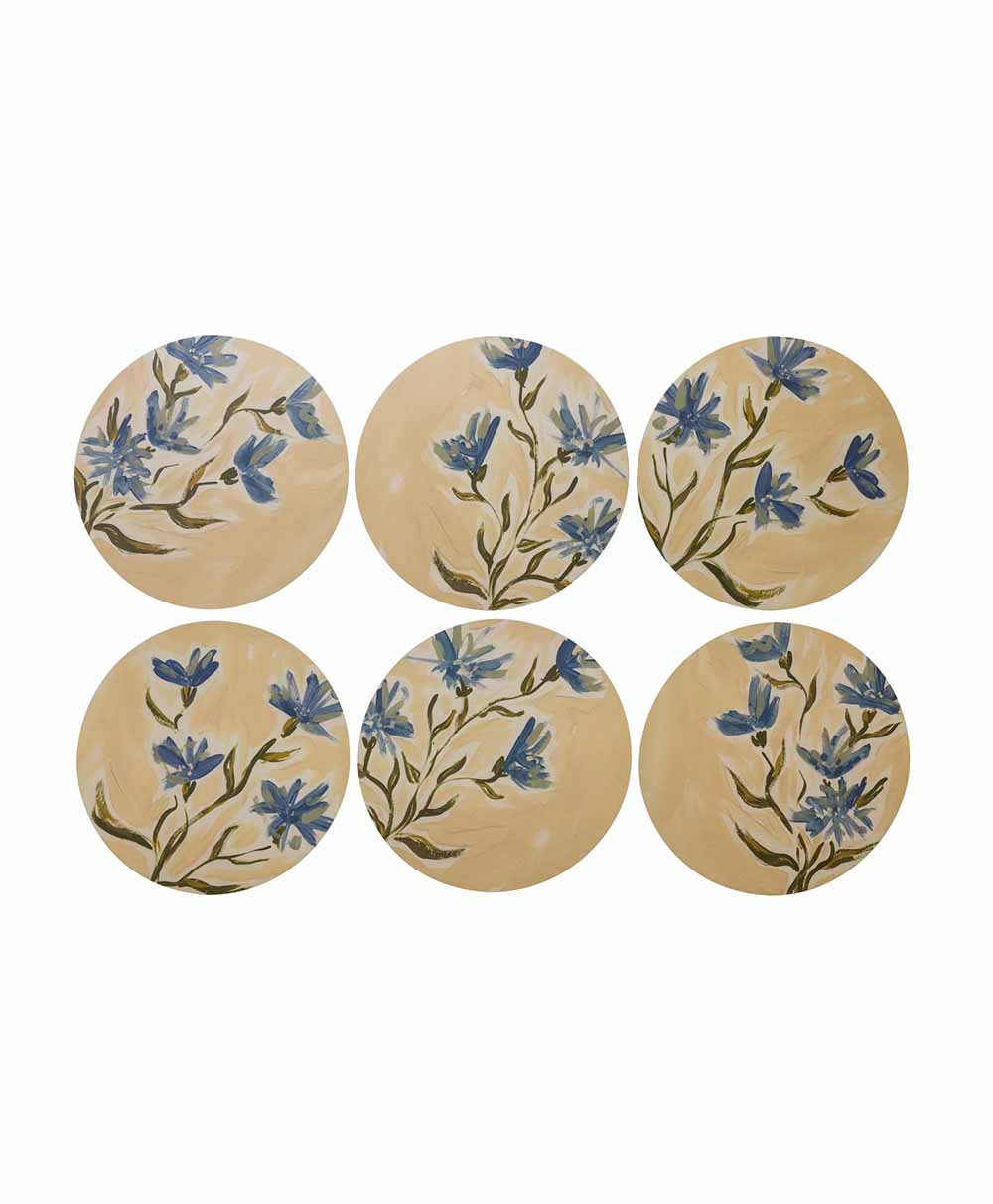 Six round plates with a light beige background, each decorated with hand-painted blue flowers and green stems, arranged in two rows of three on a white surface.