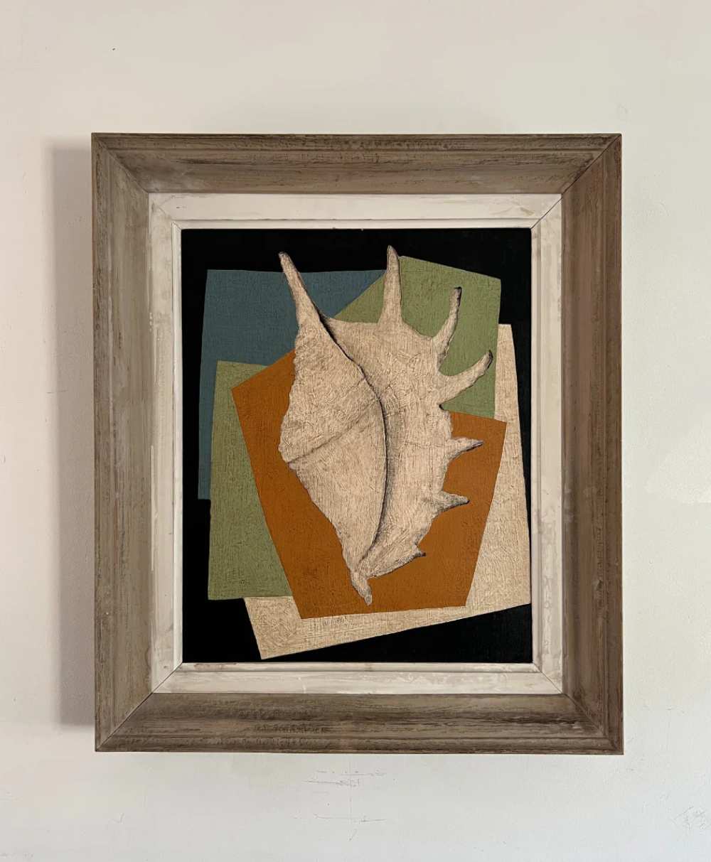 Framed artwork of a textured conch shell overlaid on layered, colorful rectangular shapes in green, black, orange, and beige, set against a plain wall.