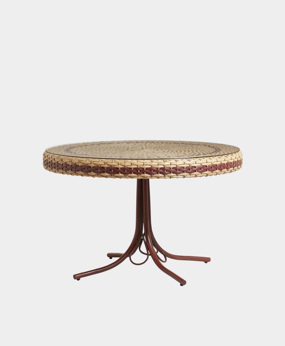 A round woven rattan table with a thick edge, supported by a brown metal base with four curved legs, set against a plain white background.