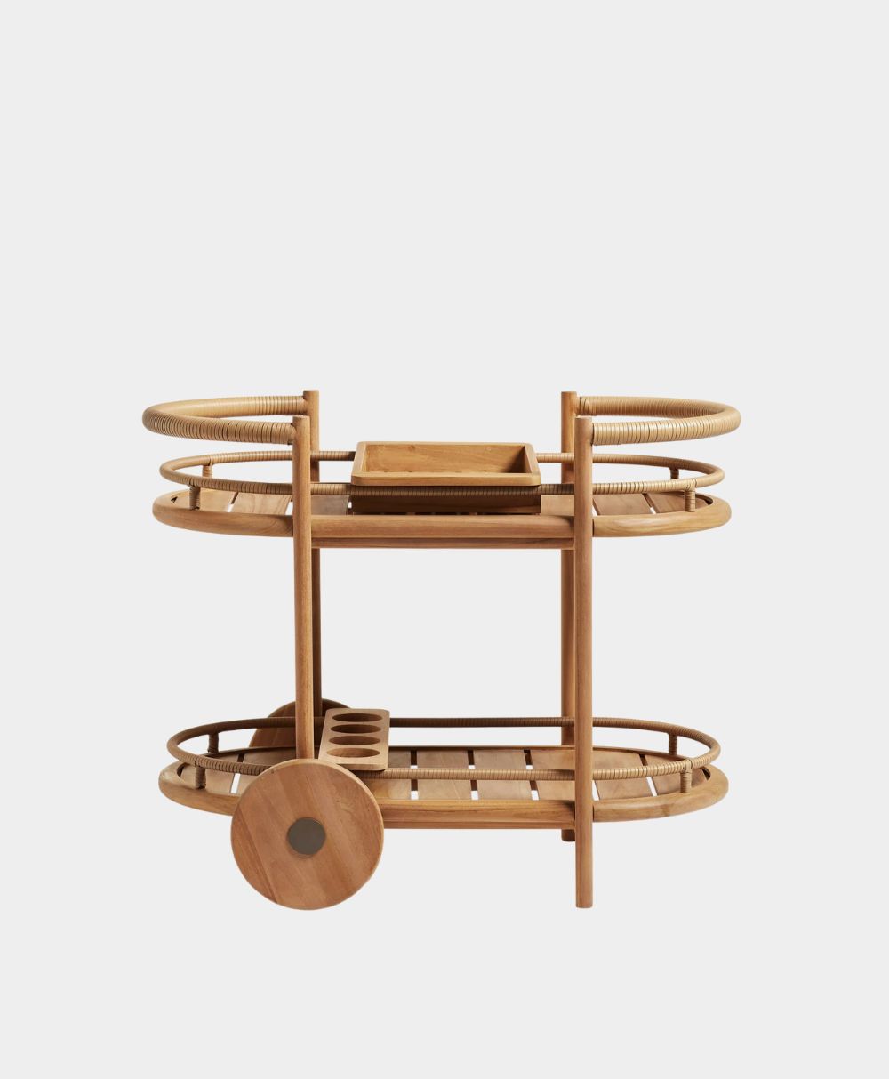 A wooden bar cart with two shelves, circular handles, two large wheels, and a small rectangular tray on the top shelf, shown against a plain white background.