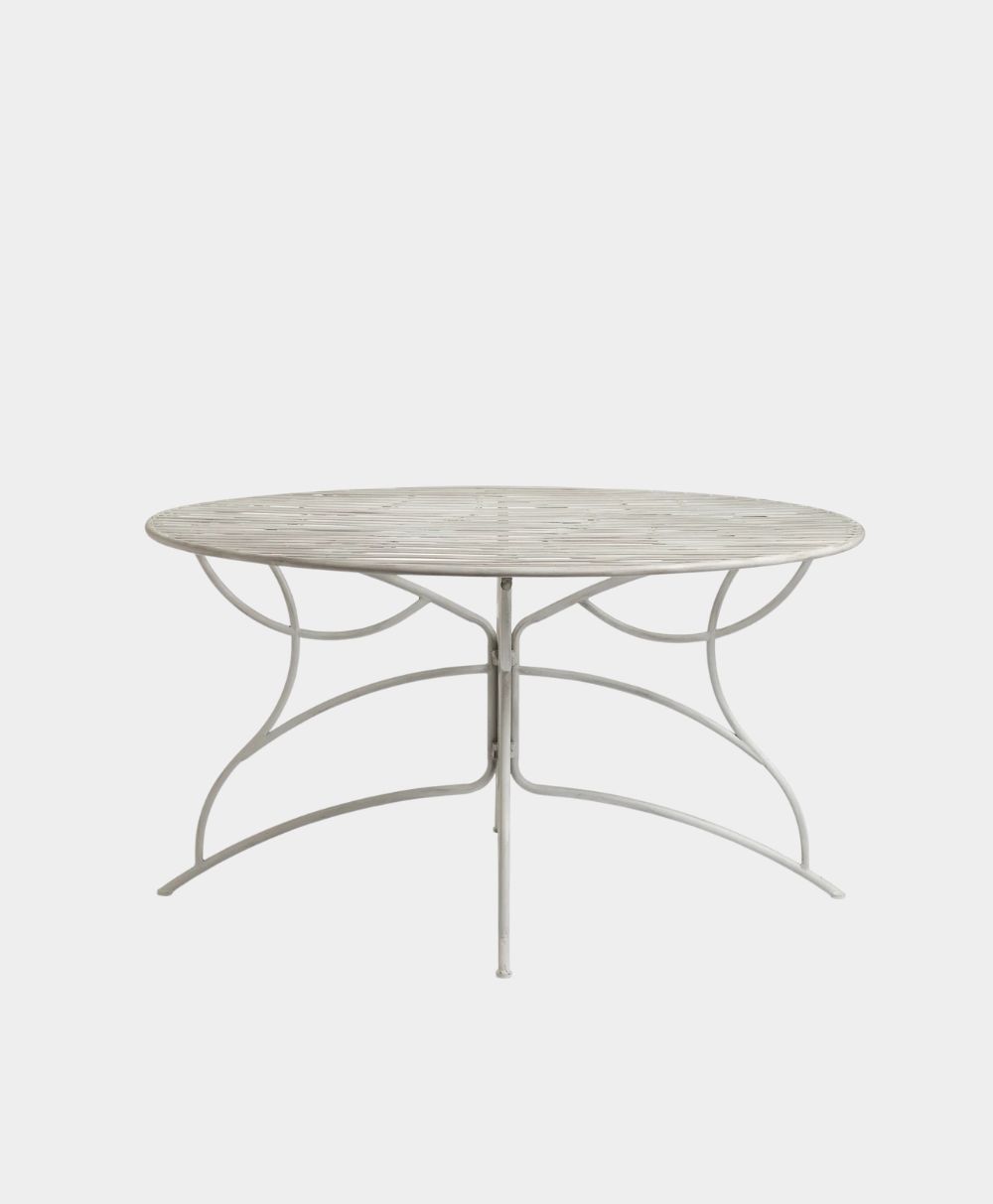 A round, white metal table with a patterned top and curved legs, photographed against a plain white background.