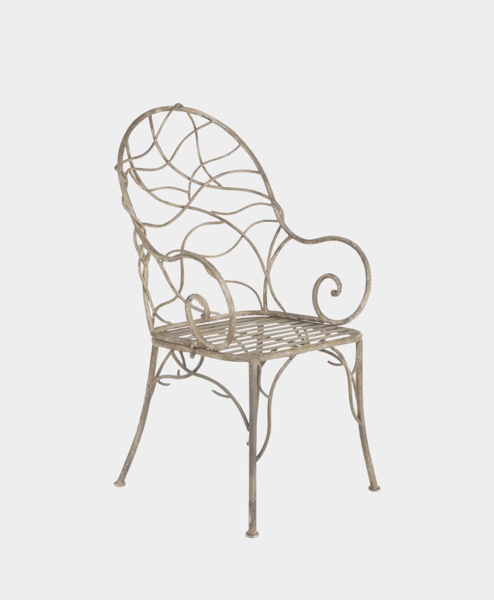 A decorative metal chair with an ornate, swirling, leaf-like backrest and armrests, and a slatted seat, set against a plain white background.