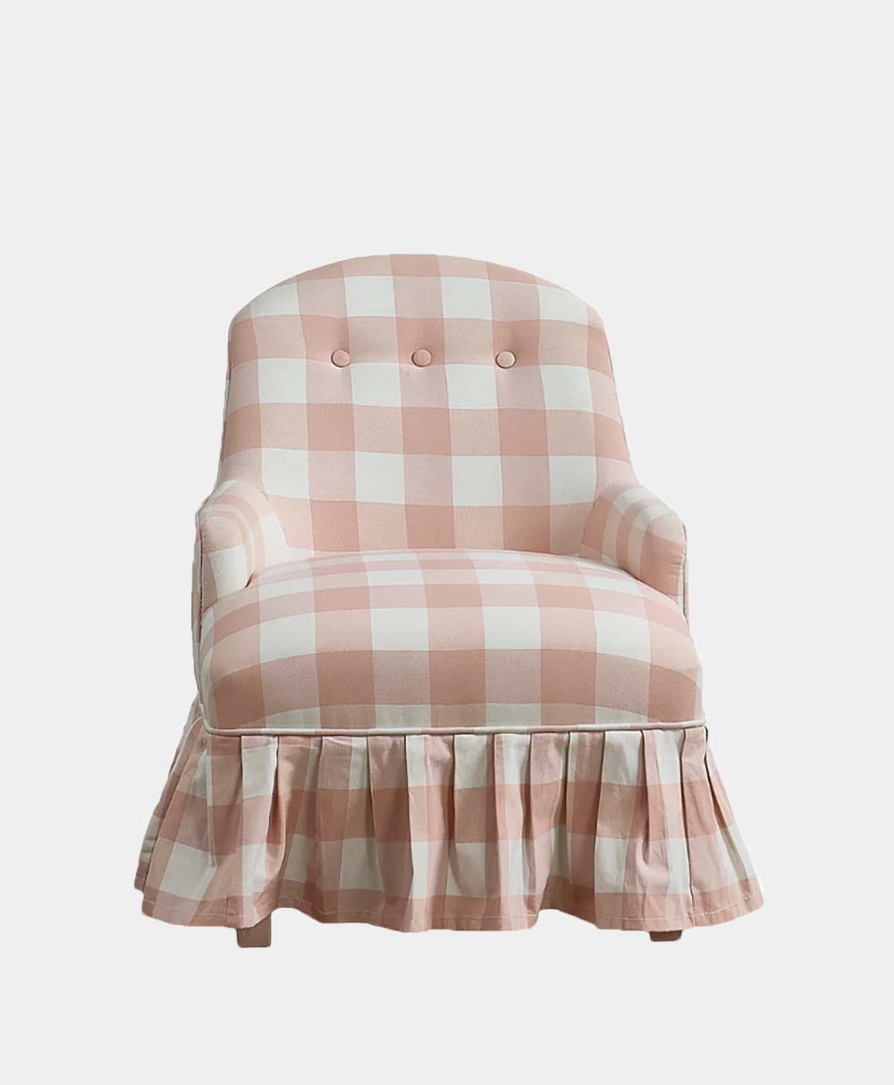 A pink and white checkered armchair with a ruffled skirt, two round buttons on the backrest, and rounded armrests, set against a plain white background.