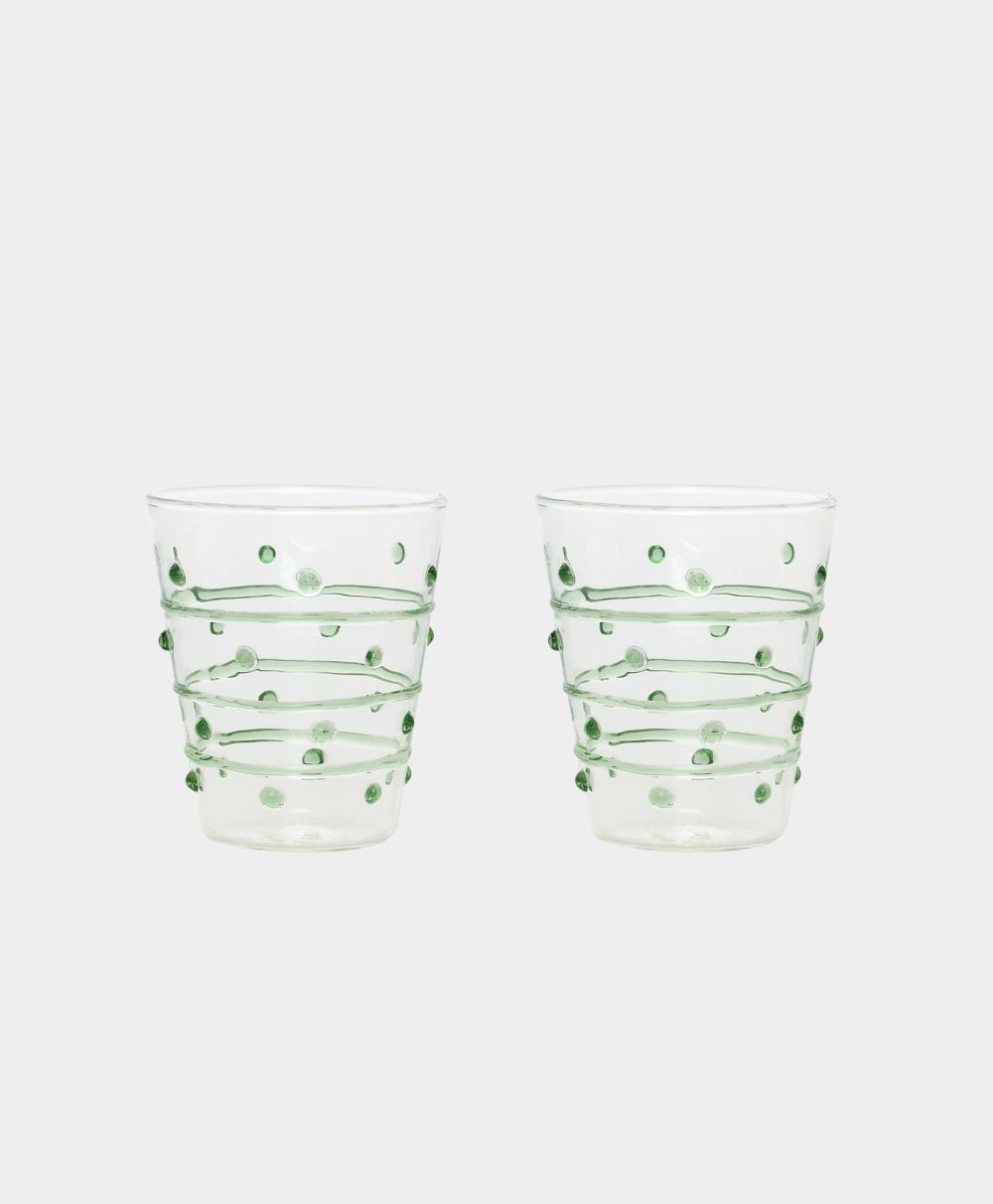 Two clear glass tumblers are decorated with green raised dots and horizontal green glass lines against a plain white background.