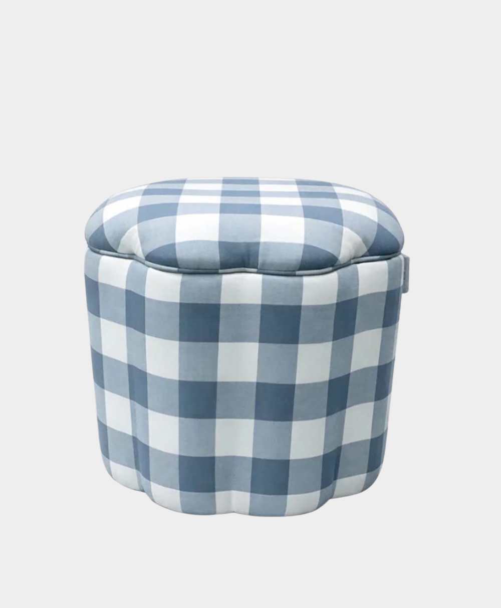 A round ottoman with a scalloped edge and a blue and white checkered fabric pattern, set against a plain light gray background.