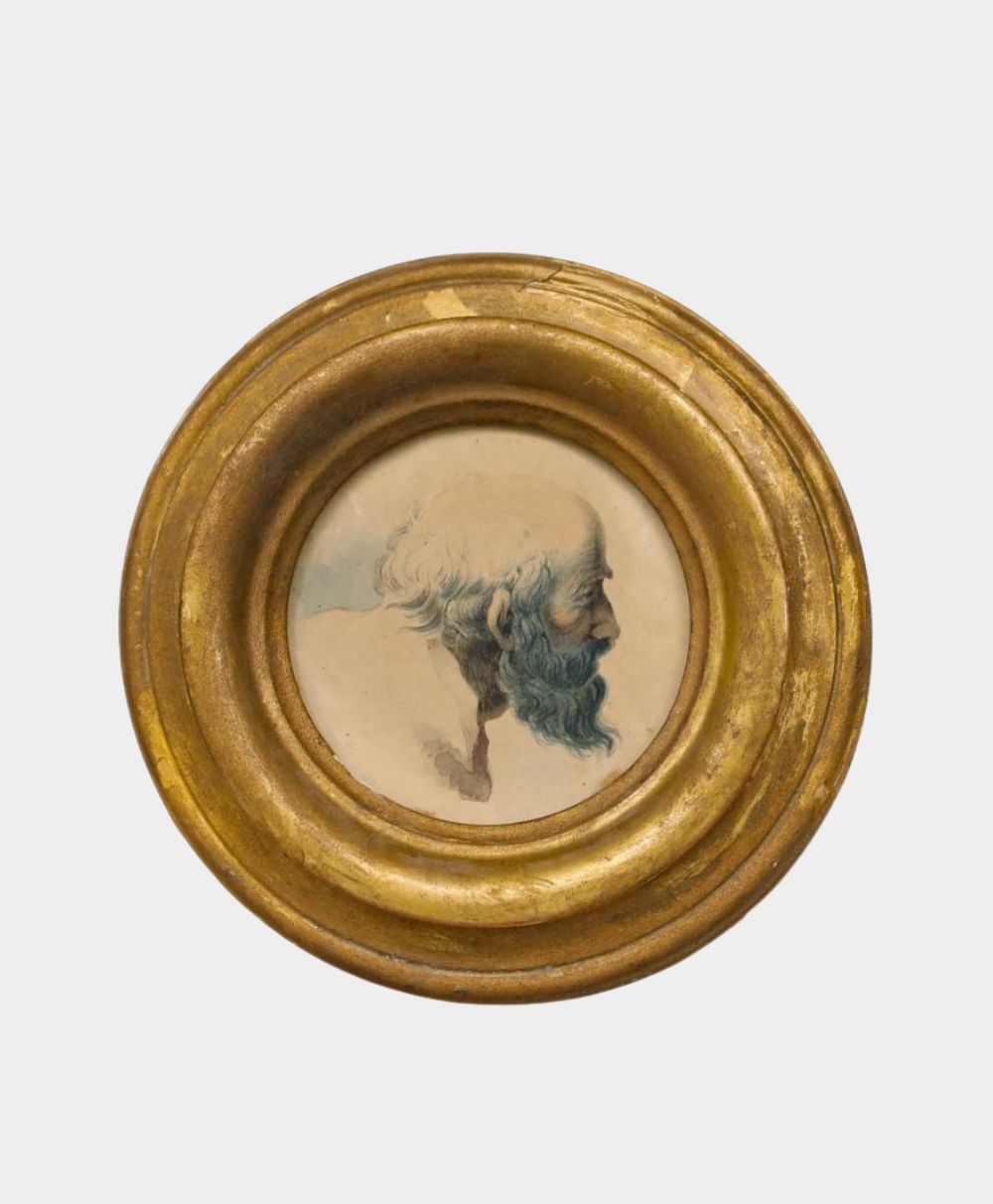 A round, gold-framed artwork featuring a side profile painting of an elderly man with a bald head and a blue-gray beard on a light background.