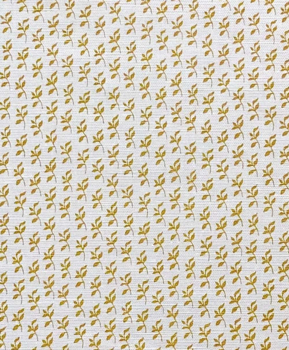 A close-up of a white textured surface with a repeating pattern of small yellow floral motifs arranged in evenly spaced rows and columns.