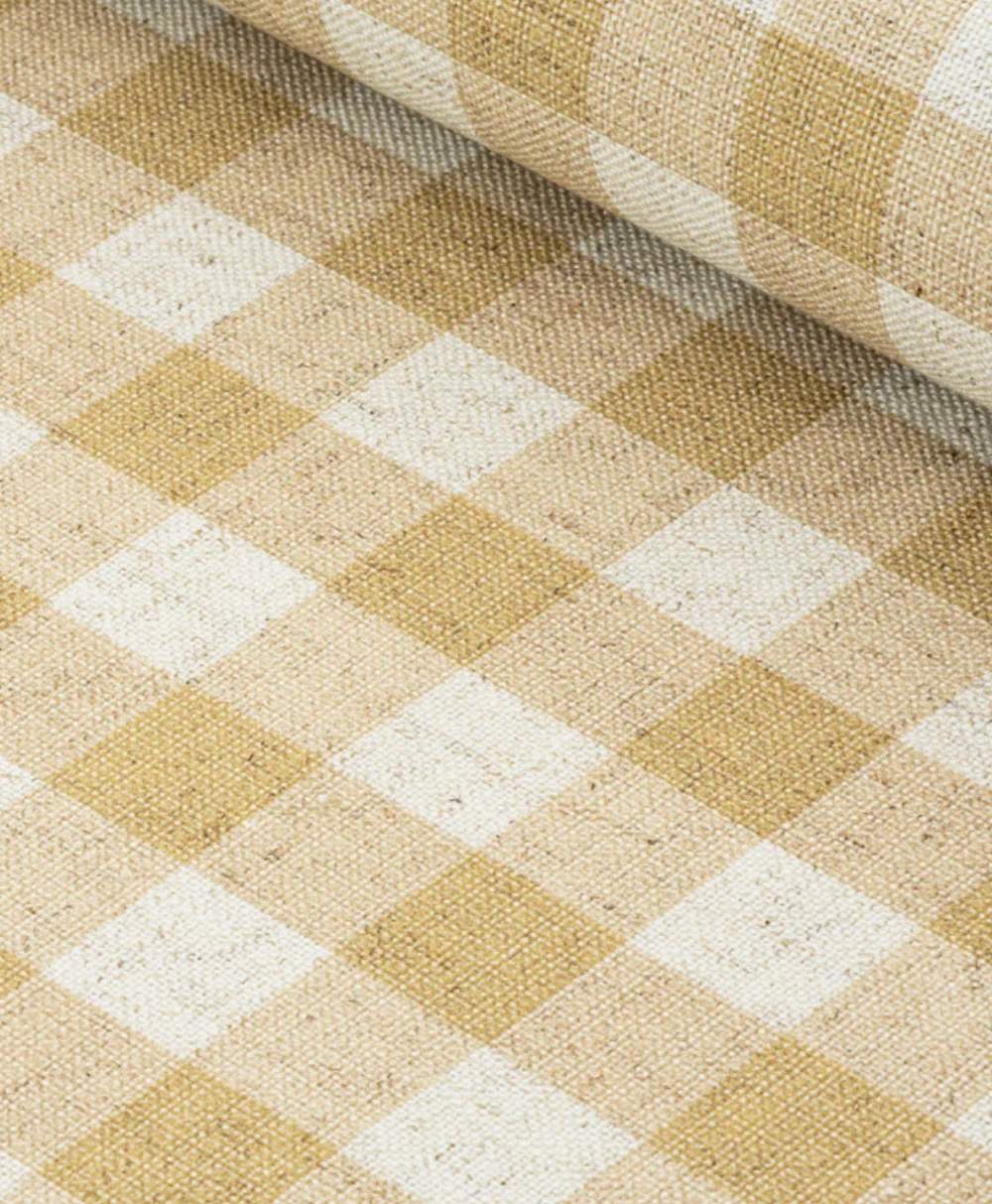 A close-up view of a fabric roll featuring a beige and white checkered pattern with a textured, woven surface. The pattern consists of alternating light and pale yellow squares.