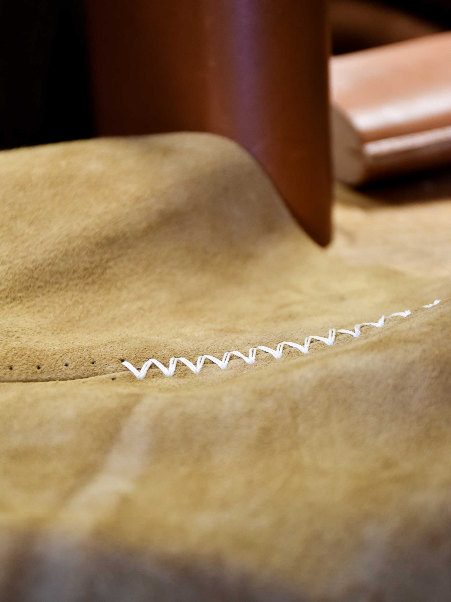 Full thickness suede being cut and laminated at OTZI’s Norfolk workshop — bespoke leather furniture making process