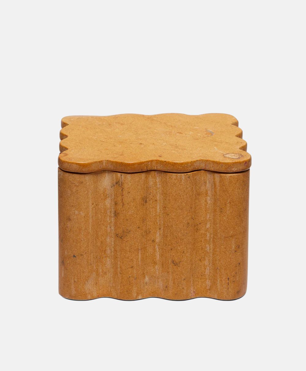 A small, light brown, rectangular box with wavy edges on both the lid and sides, resembling a biscuit or cracker, set against a plain white background.