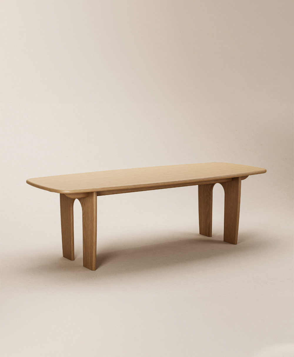 A minimalist wooden bench with smooth edges and arched legs, set against a plain beige background.