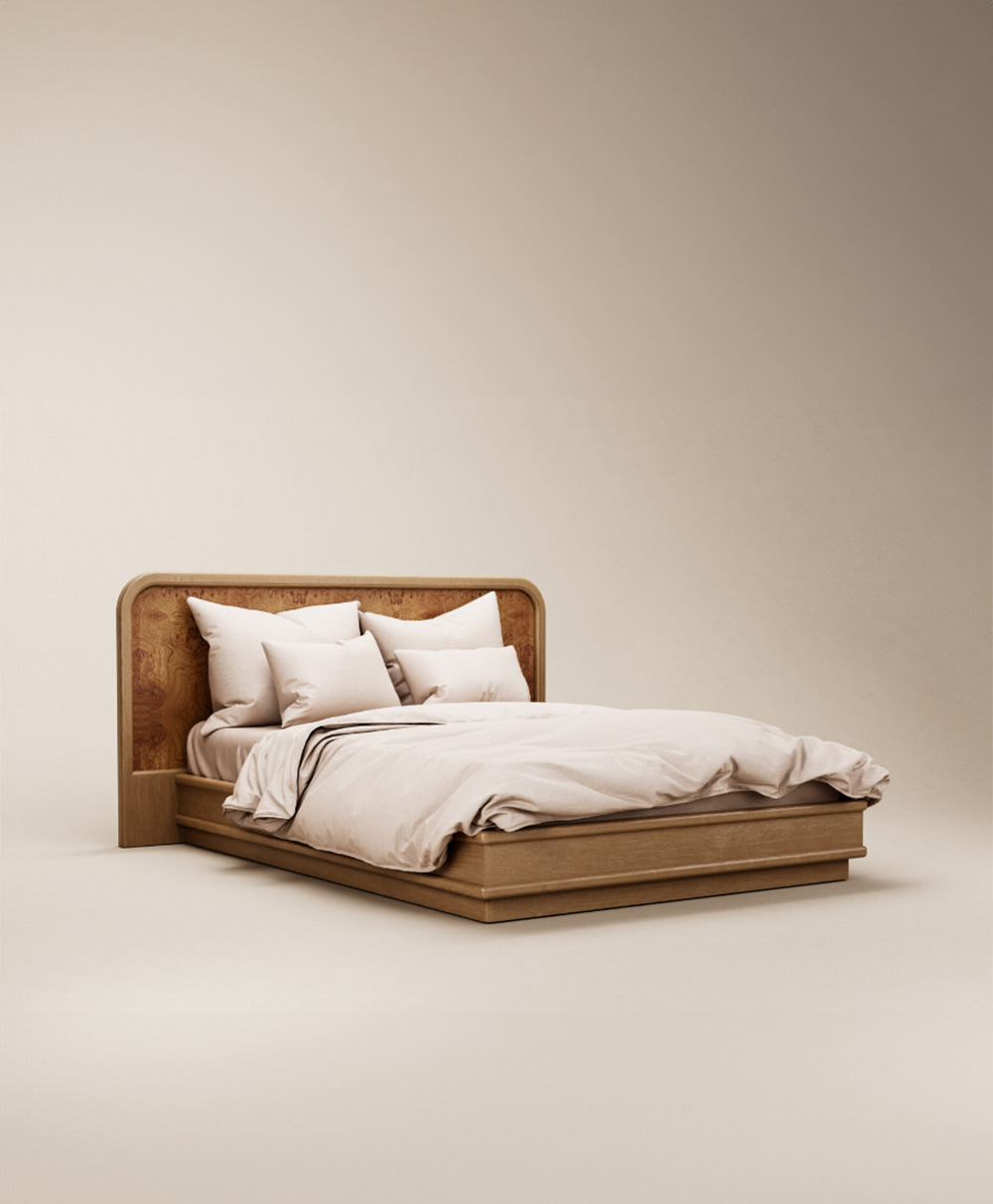 A modern wooden bed with a curved headboard, neatly made with beige bedding and four white pillows, set against a plain light background.