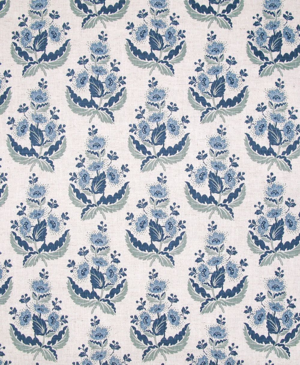 A repeating pattern of blue and light blue floral bouquets with green leaves on a light beige background, creating a symmetrical and vintage-style fabric design.