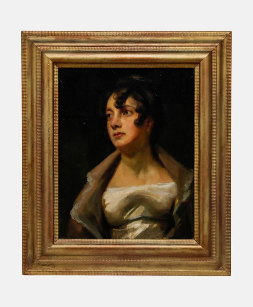 A classical oil painting of a woman with dark hair, wearing a white dress and a shawl, gazing to the left. The portrait is set in an ornate, gold-colored wooden frame against a dark background.