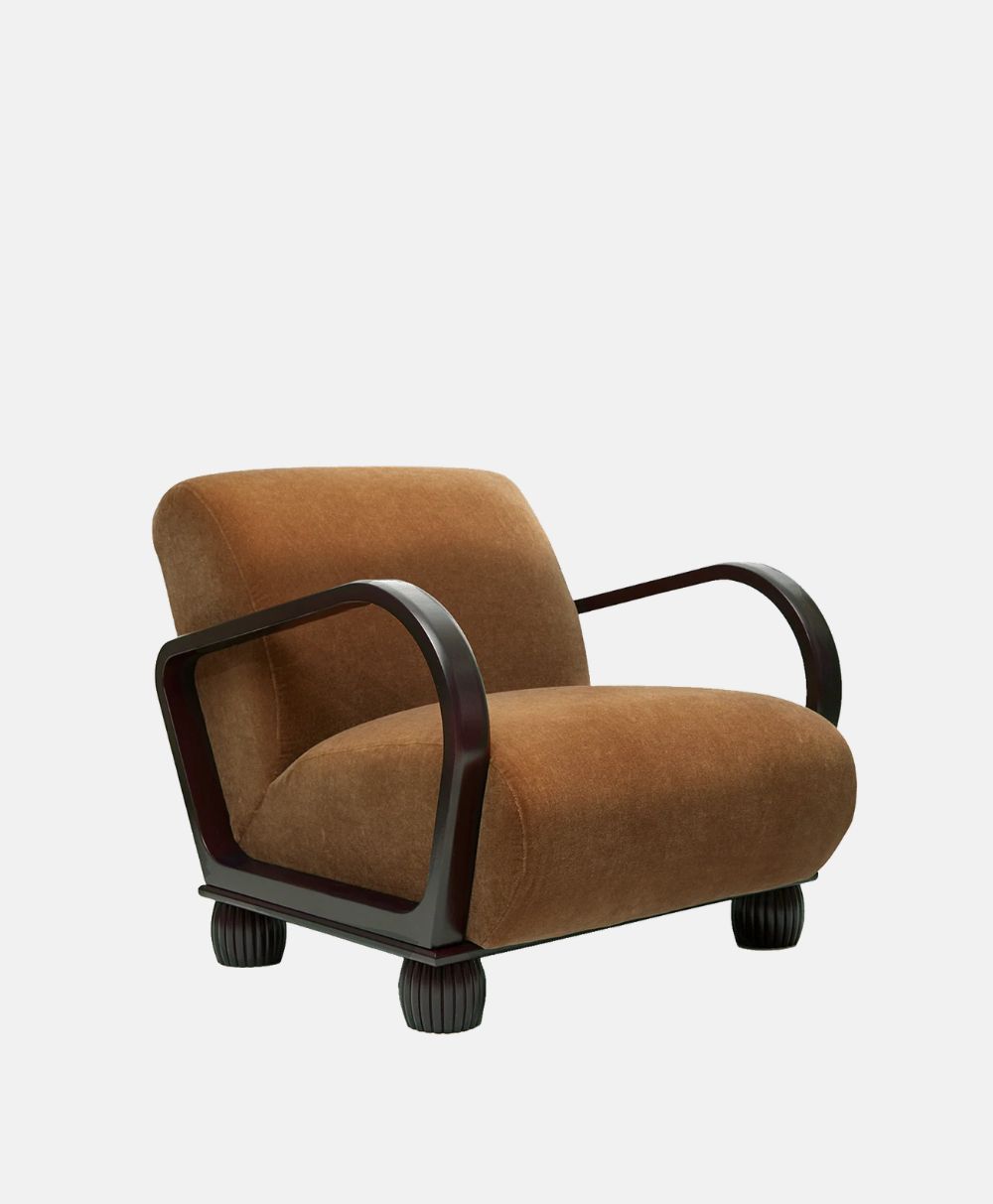 A plush, brown upholstered armchair with wide, curved dark wooden arms and legs, set against a plain white background.
