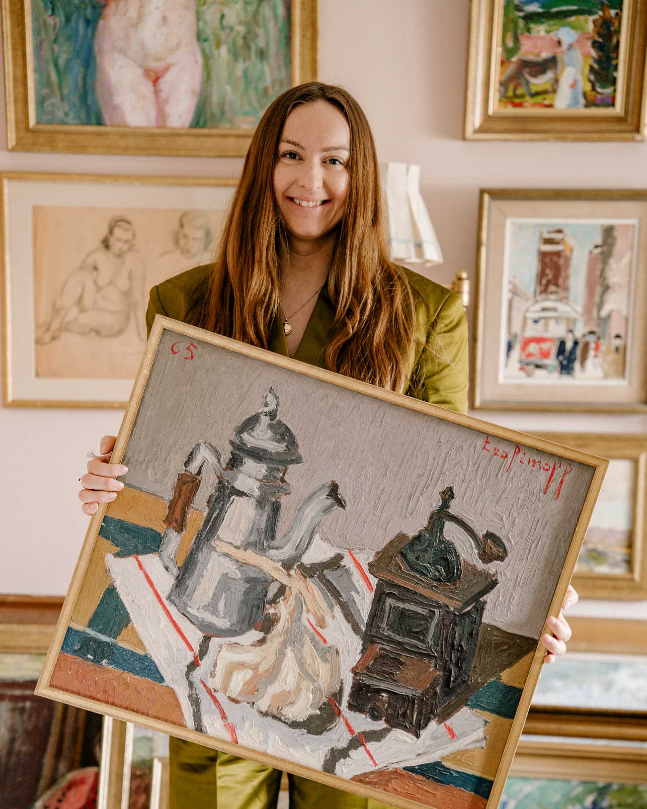 Annalise Holasz stands in the Hue + Holasz studio, Bath, UK, holding a textured French vintage oil painting
