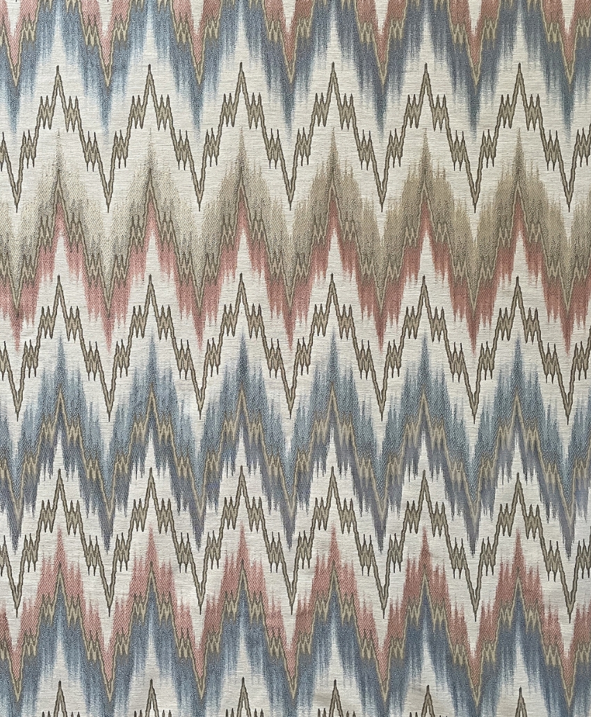 Decorative zigzag patterned fabric in muted blue, pink and earthy tones by Teyssier. Scheme, UK
