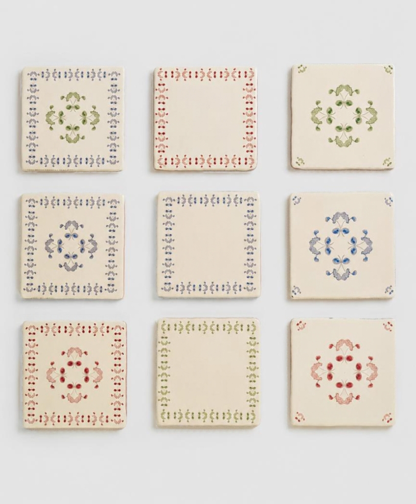 Collection of decorative square tiles featuring delicate floral motifs and ornamental borders in soft pastel shades by The CL Collection. Scheme, UK